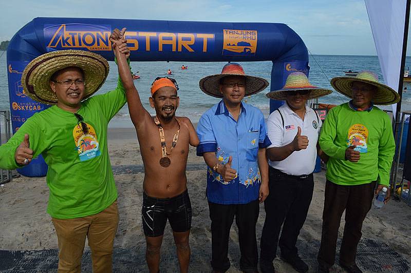 National para-athlete Mohd Sabki Arifin crosses the finishing line after completing 6km swim off Tanjung Rhu beach