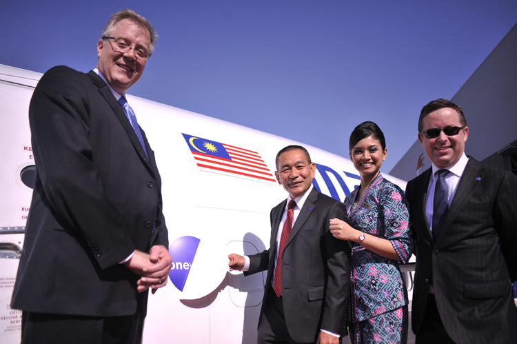 Malaysia Airlines' cabin crew with Malaysia Airlines Group CEO Ahmad Jauhari Yahya (second from left) and Malaysia Airlines Chairman Tan Sri Md Nor Yusof (second from right) giving the thumbs up. In the background is Malaysia Airlines' B737-800 with the oneworld livery.