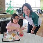 CX Country Manager Mary Chan serving a child