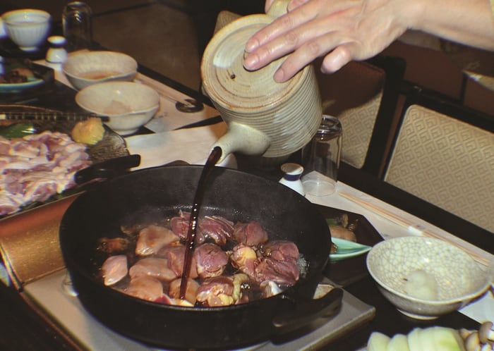 Slices of ‘omi’ chicken simmered in soy sauce in sukiyaki dish.