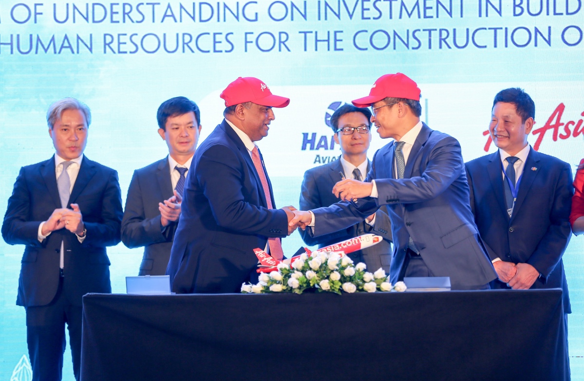 AirAsia Group CEO Tony Fernandes (front centre left) shakes hands with Tran Trong Kien, CEO of Thien Minh Travel Joint Stock Company CEO and General Director of Hai Au Aviation Joint Stock Company, after the memorandum signing witnessed by Vietnamese Deputy Prime Minister Vu Duc Dam (centre right) and Vietnamese Deputy Minister of Culture, Sports and Tourism Le Quang Tung (centre left), flanked by the Vice Chairmen of the Vietnamese Advisory Council to the Prime Minister on Administrative Procedures Reform, VinaCapital Group CO-Founder and CEO Don Lam (far left) and FPT Corporation Co-Founder, Chairman and CEO Truong Gia Binh (far right), who is also Chairman of Vietnam's Private Sector Development Committee.