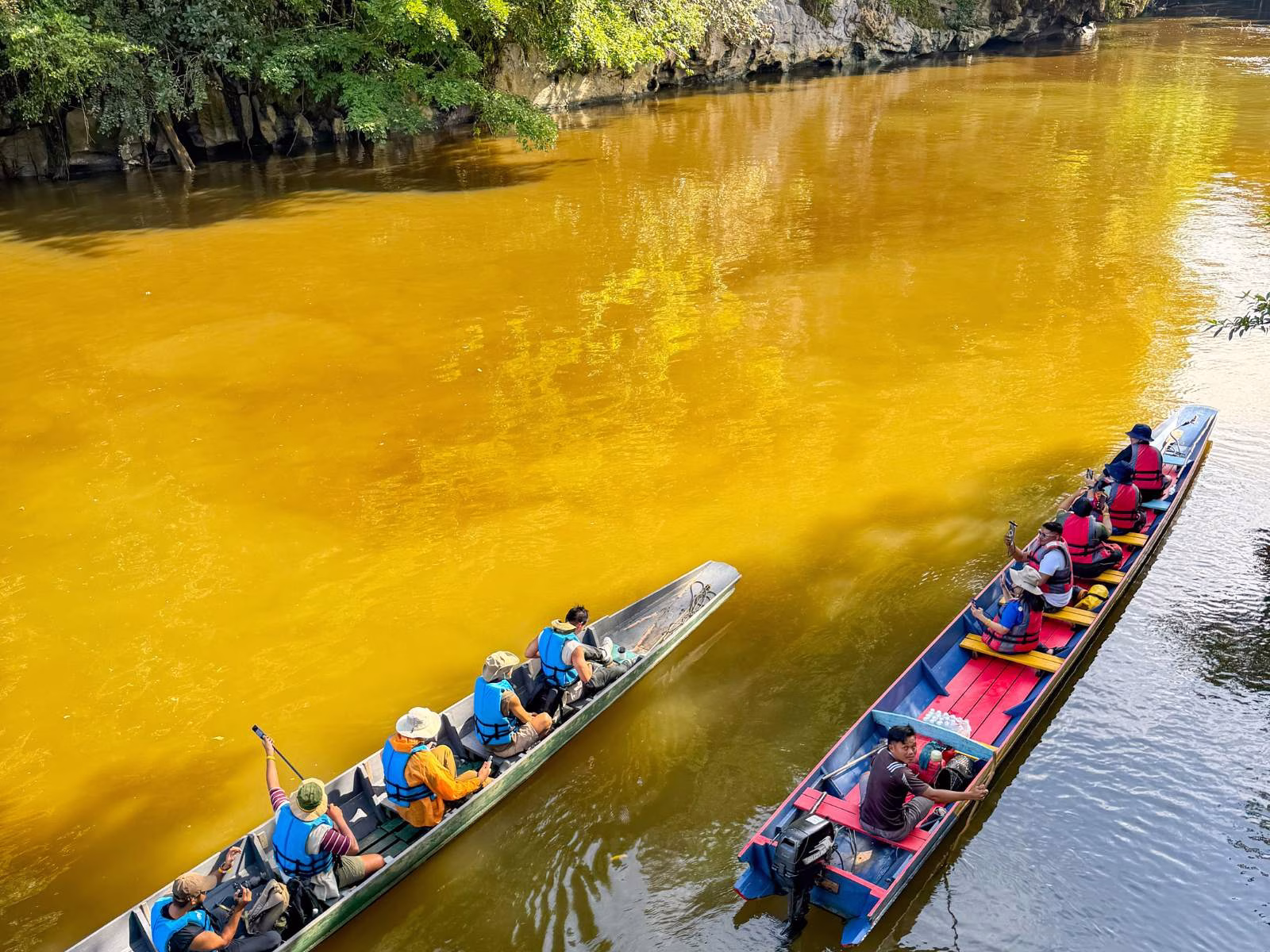 Longboat on the Melinau River surrounded by dense rainforest near Clearwater Cave in Mulu National Park, Sarawak.