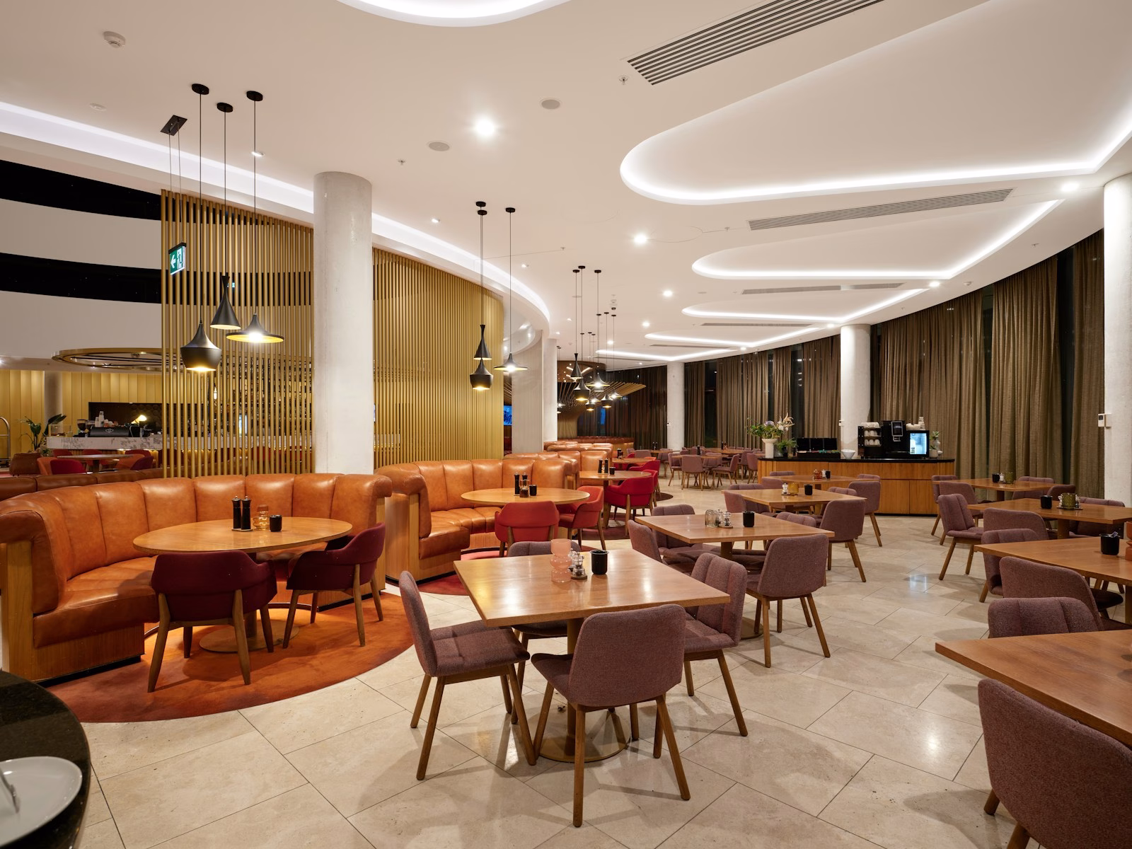 Modern restaurant interior with booth seating and tables.