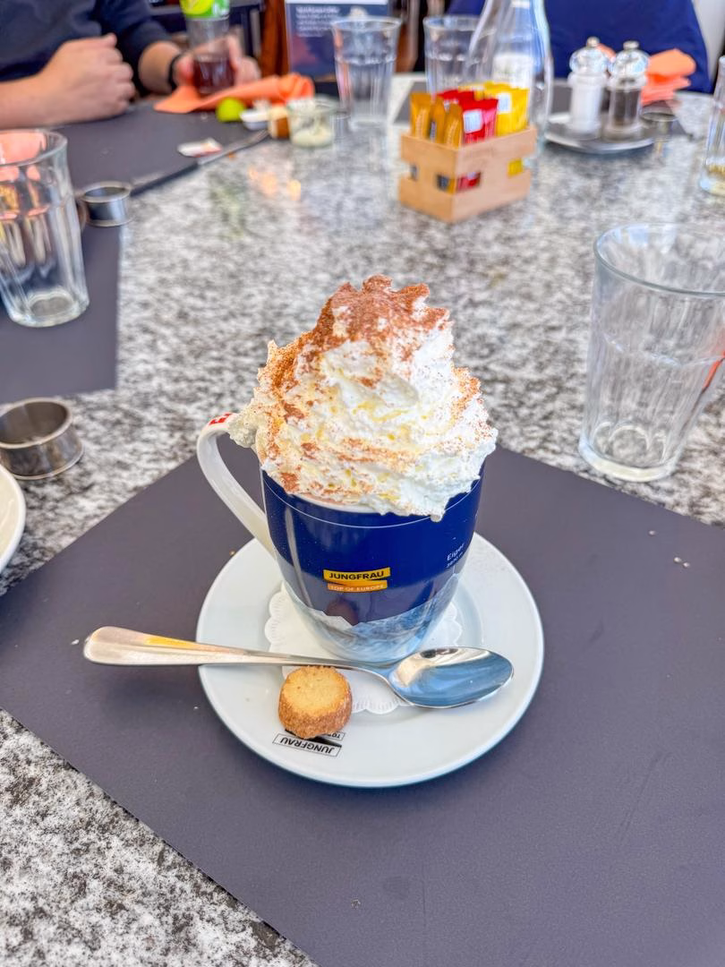 A cup of hot chocolate topped with whipped cream at Restaurant Crystal on Jungfraujoch in Switzerland.