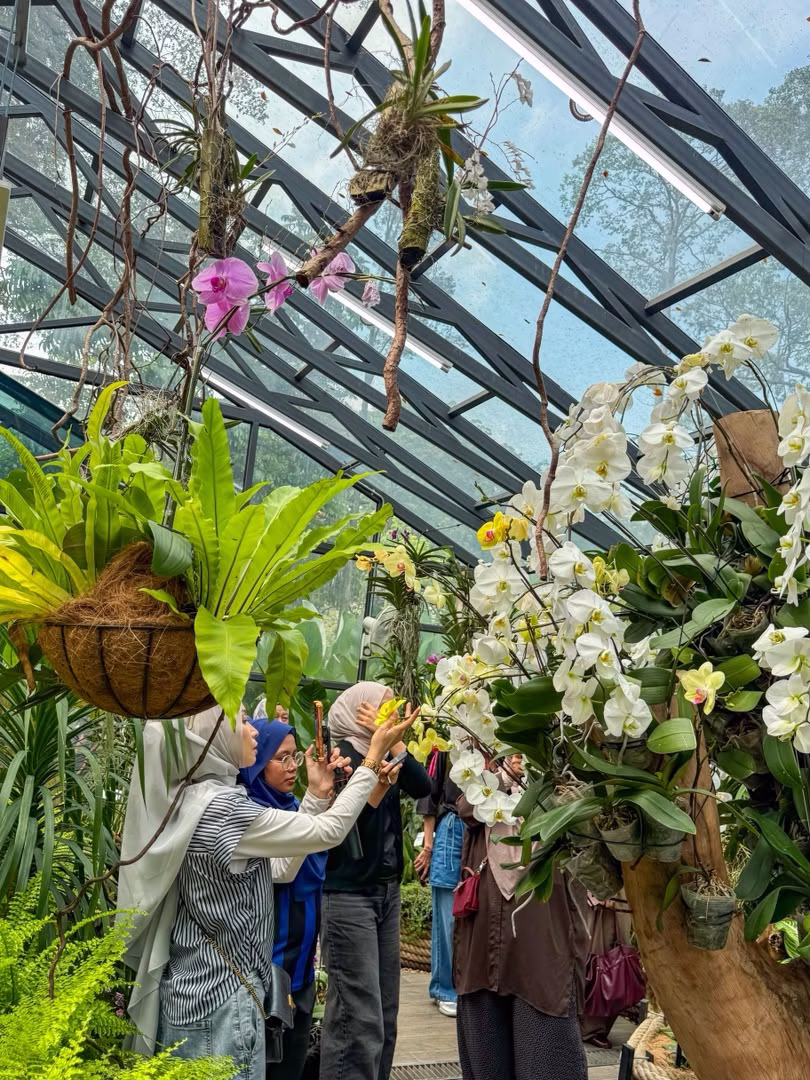 Visitors admiring orchid species inside the glasshouse at Taman Anggerik Shah Alam