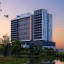 ASAI Gamuda Cove hotel building surrounded by greenery and a reflective pond at sunset in Gamuda Cove, Selangor, Malaysia.