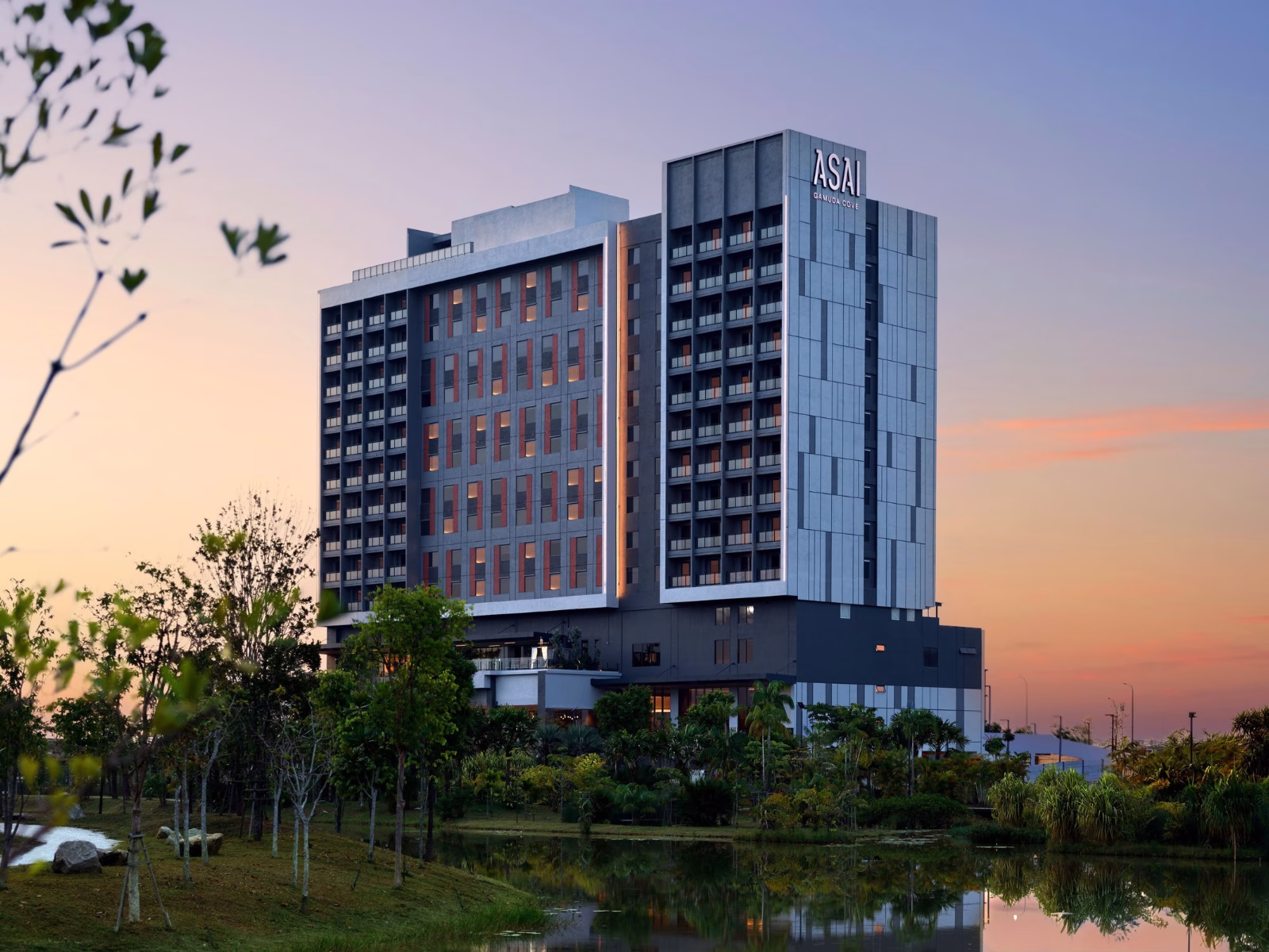 ASAI Gamuda Cove hotel building surrounded by greenery and a reflective pond at sunset in Gamuda Cove, Selangor, Malaysia.